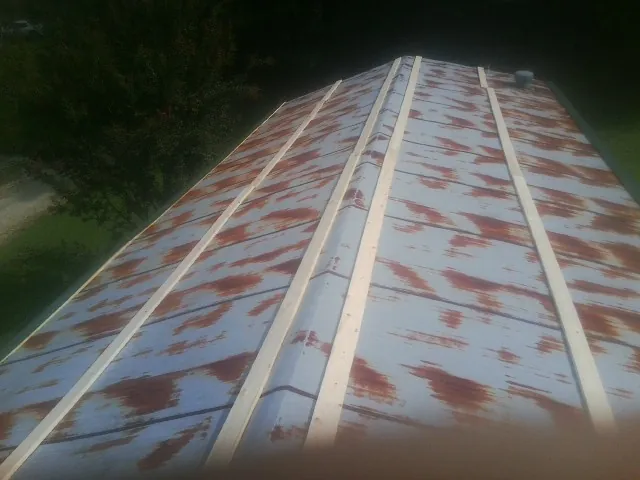 Rusted metal roof panels with new wood purlins before replacement — Storm Damage Roof Repair in Buxton by Roofing Brothers