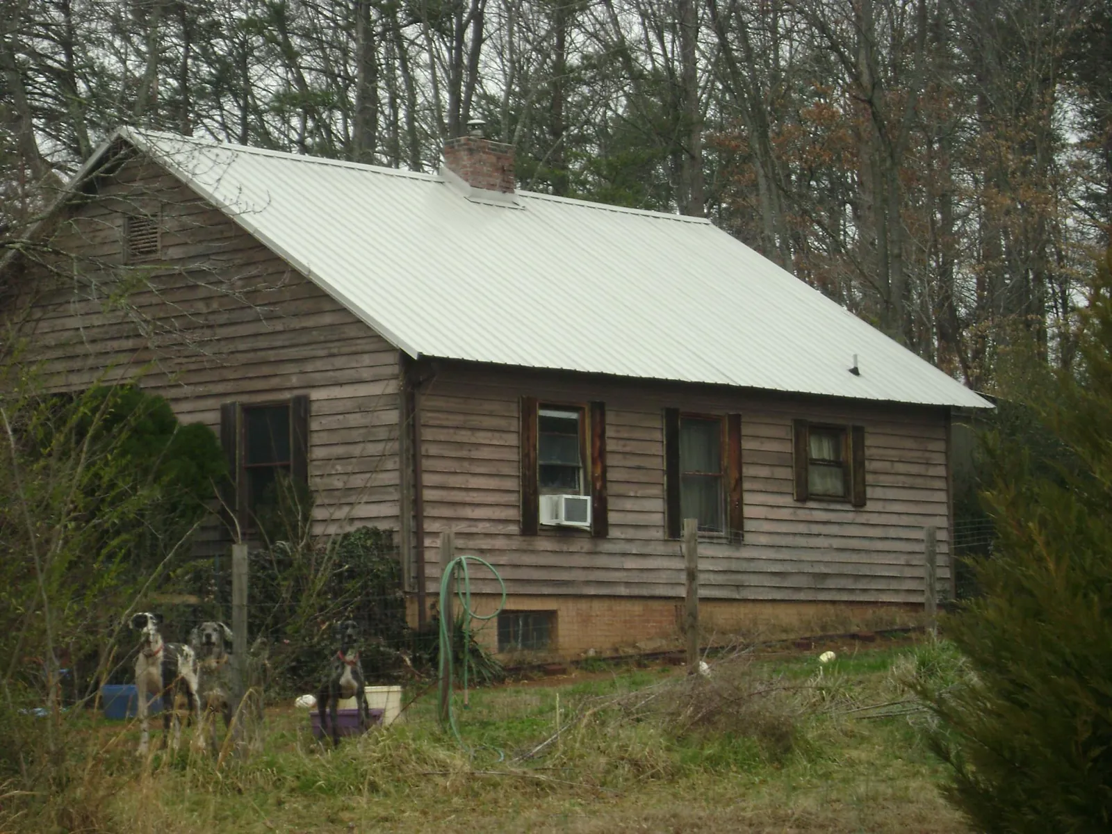 White metal roof on an old wood sided farmhouse, from a Metal Roof Installation job in Buxton